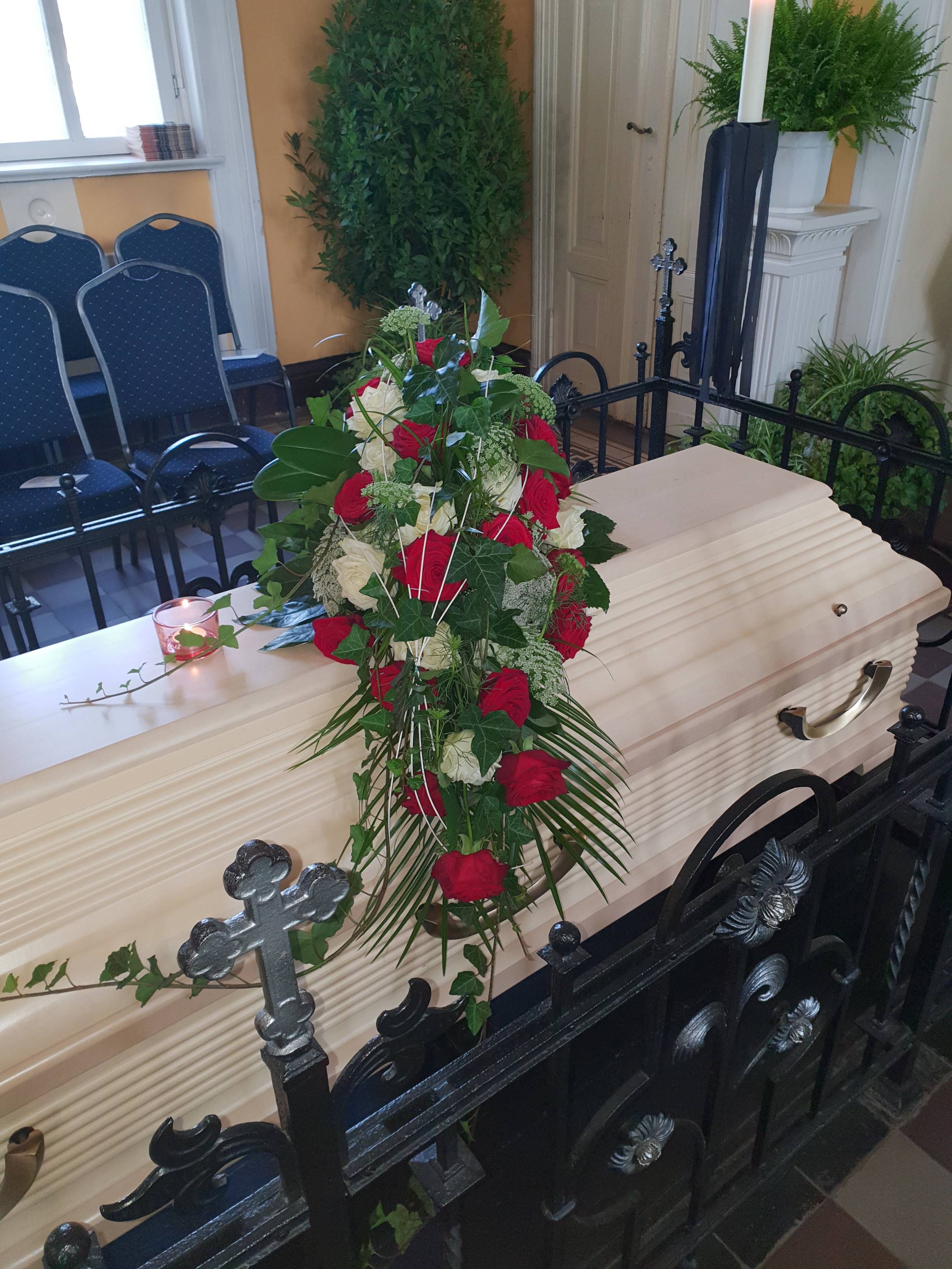 Bild von einem geschmücktem Sarg in einer Kapelle aus einer anderen Perspektive